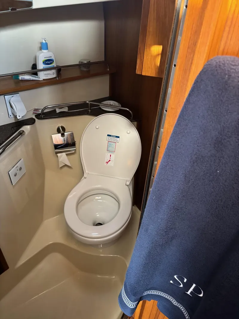 Slide: The Image of 2024 Ranger Tugs R31S bathroom interior with toilet and towel. - 7