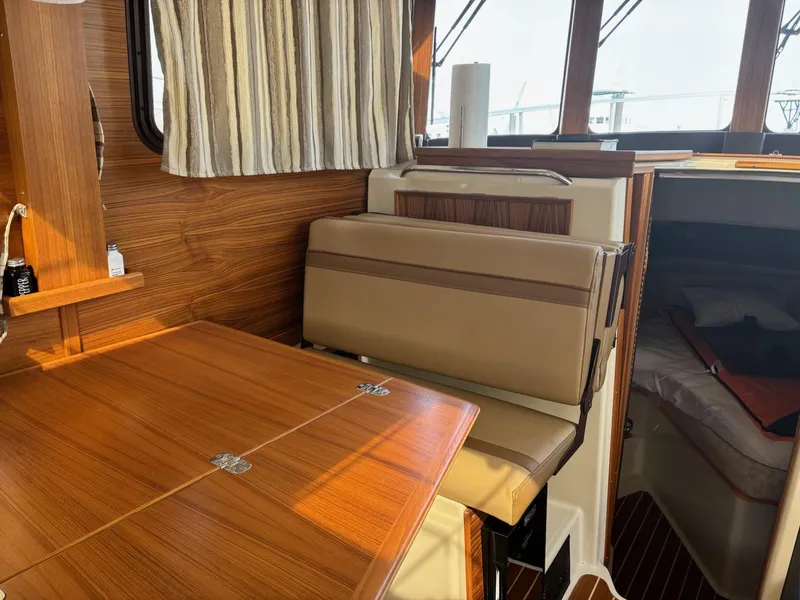 Slide: The Image of 2024 Ranger Tugs R31S interior with wood finish and seating area. - 8