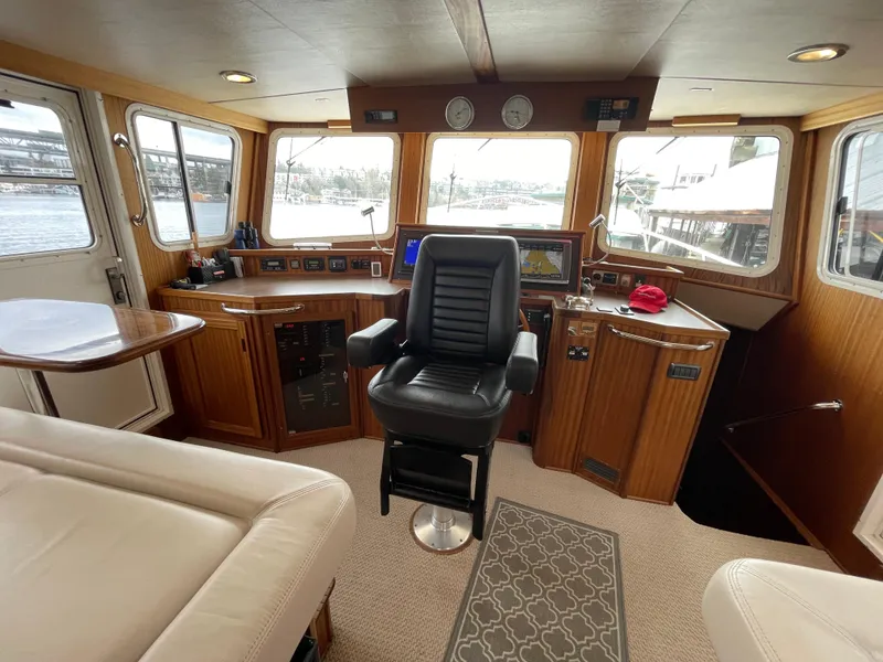 Slide: The Image of Pilothouse interior of 2009 American Tug 49 Limited, featuring captain's chair and navigation equipment. - 12