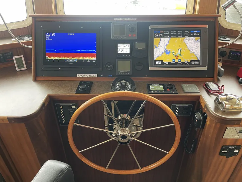 Slide: The Image of Control panel of a 2009 American Tug 49 Limited with navigation screens and steering wheel. - 13