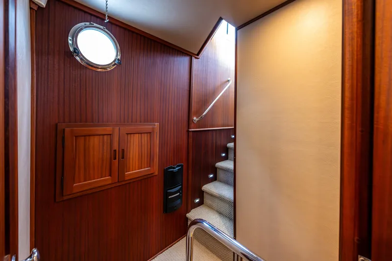 Slide: The Image of Interior of 2009 American Tug 49 Limited, featuring wooden paneling and carpeted stairs. - 15