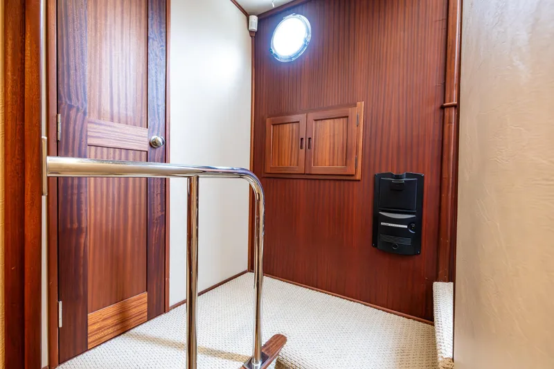 Slide: The Image of Interior of 2009 American Tug 49 Limited, featuring wood paneling and a porthole window. - 16