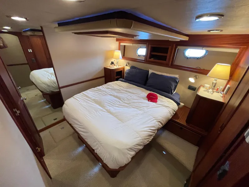 Slide: The Image of Luxurious bedroom interior of 2009 American Tug 49 Limited yacht, featuring cozy bedding and elegant wood finishes. - 17