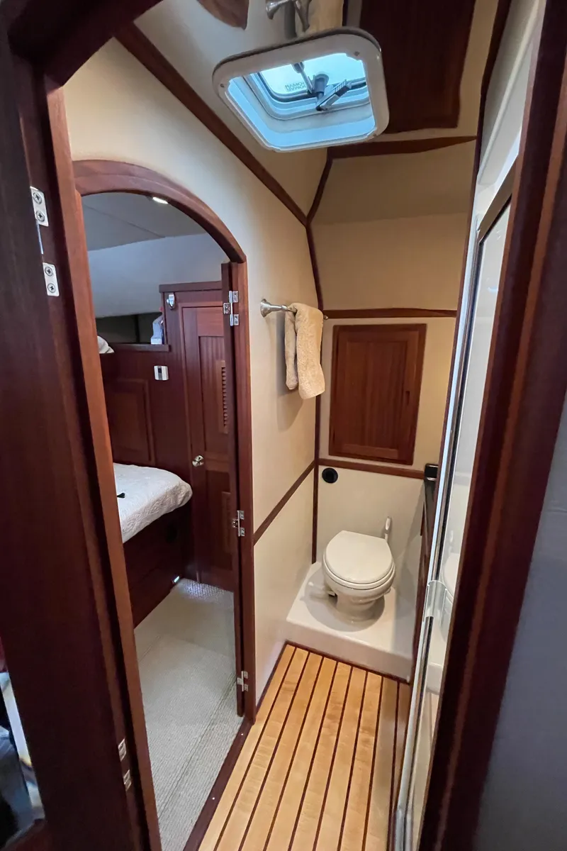 Slide: The Image of 2009 American Tug 49 Limited bathroom with wooden accents and skylight. - 28