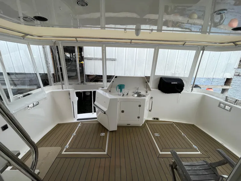 Slide: The Image of 2009 American Tug 49 Limited deck with sink, grill, and seating area. - 31