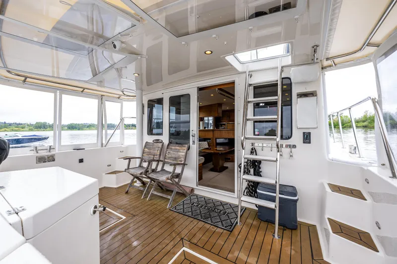 Slide: The Image of Spacious deck of 2009 American Tug 49 Limited with seating and ladder access. - 36