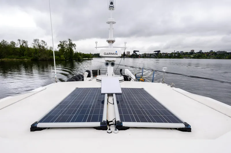 Slide: The Image of 2009 American Tug 49 Limited with solar panels on deck, cruising on a calm river. - 37