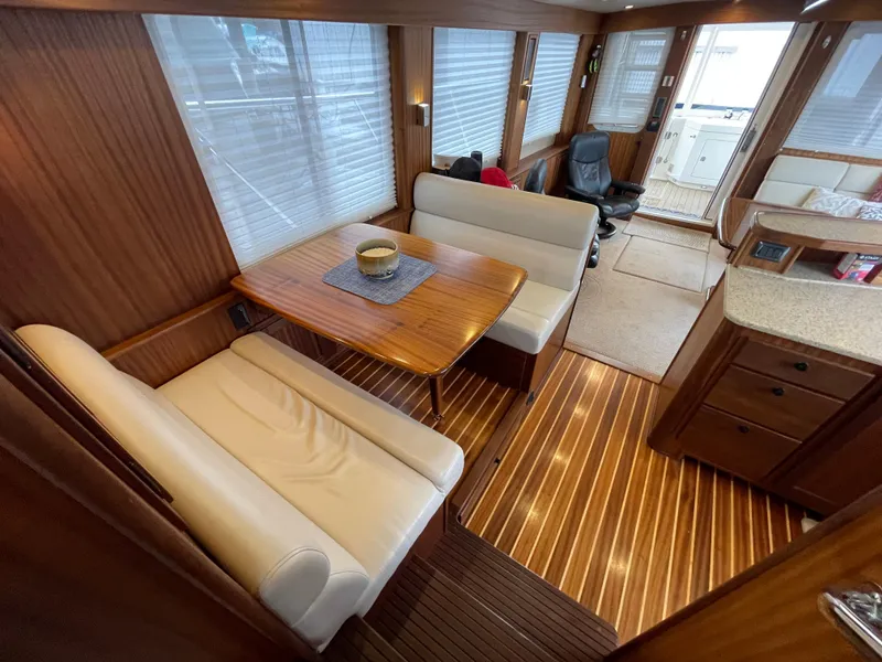 Slide: The Image of Interior of 2009 American Tug 49 Limited with wooden flooring and dining area. - 5