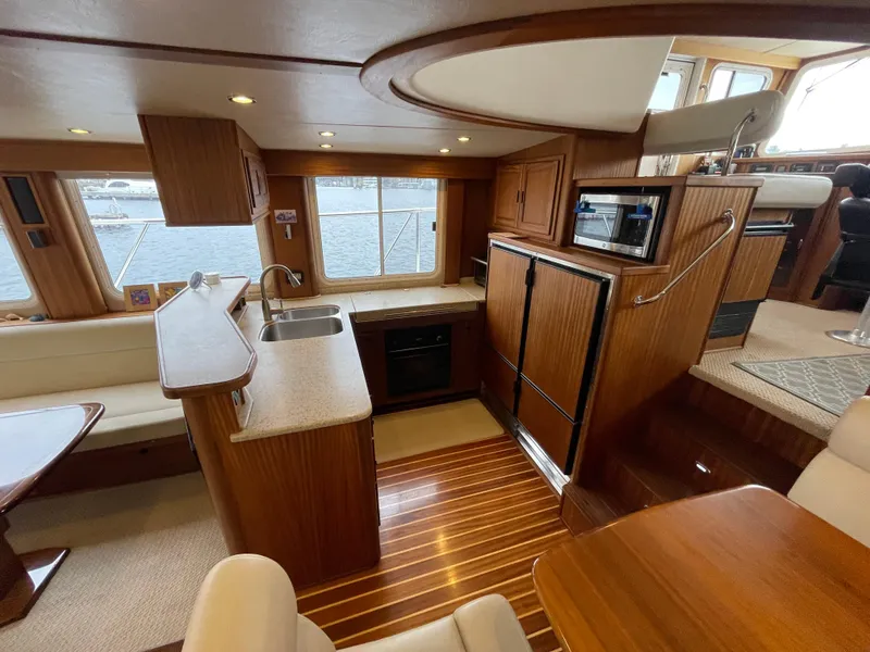 Slide: The Image of Luxurious interior of 2009 American Tug 49 Limited yacht with modern kitchen and dining area. - 6