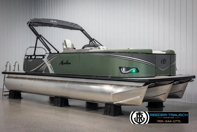 Slide: The Image of 2025 Avalon LSZ CRB pontoon boat in showroom, featuring sleek design and modern amenities. - 2