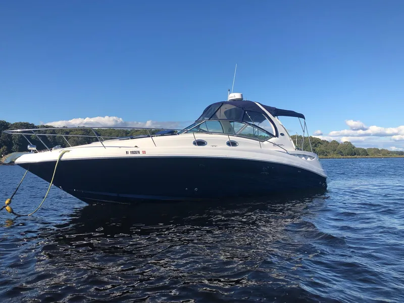 Slide: The Image of 2006 Sea Ray 320 Sundancer boat on calm water under clear blue sky. - 1