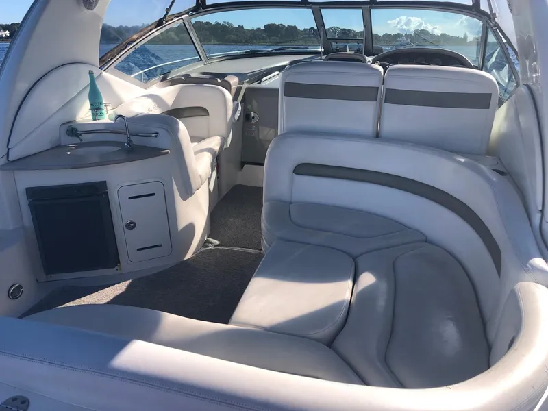 Slide: The Image of Interior of 2006 Sea Ray 320 Sundancer boat with plush seating and compact kitchenette. - 10