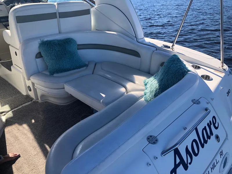 Slide: The Image of 2006 Sea Ray 320 Sundancer boat with white seating and teal cushions on a sunny day. - 16
