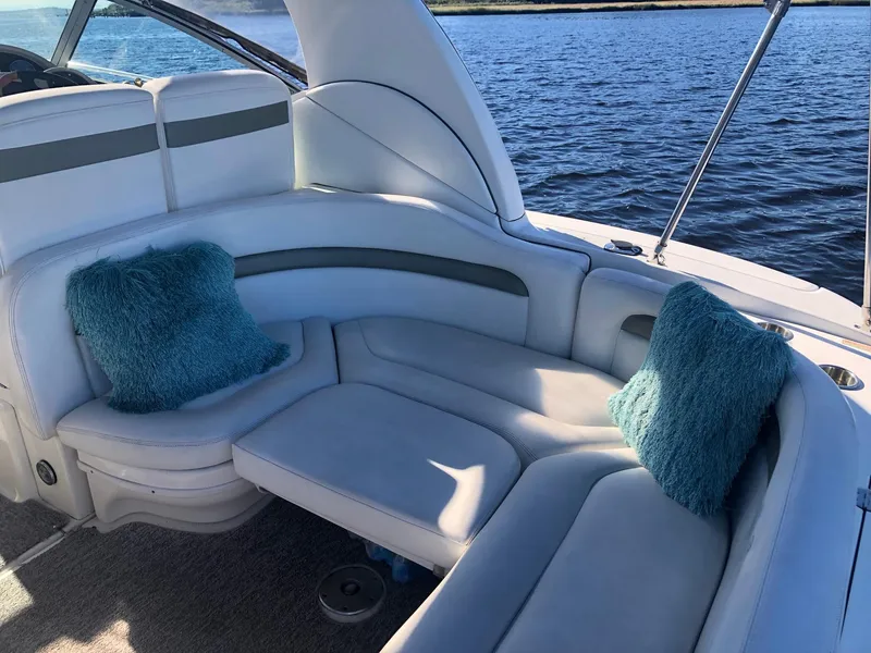 Slide: The Image of 2006 Sea Ray 320 Sundancer boat interior with plush seating and teal cushions on the water. - 17