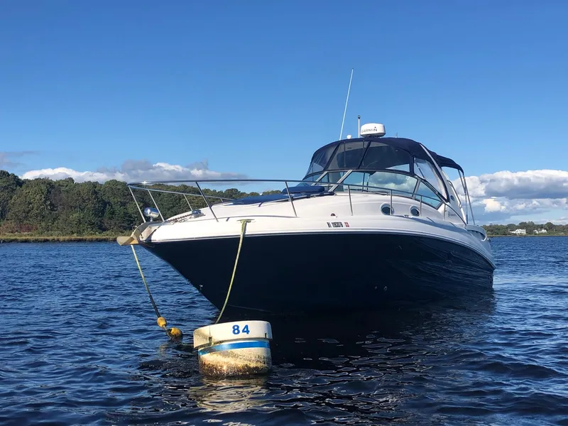 Slide: The Image of 2006 Sea Ray 320 Sundancer moored on calm water under clear blue sky. - 2