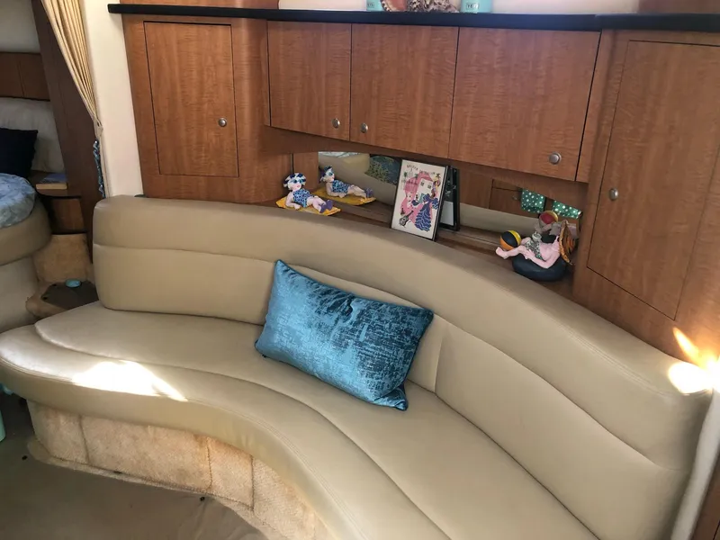 Slide: The Image of Interior of 2006 Sea Ray 320 Sundancer with curved seating and wooden cabinetry. - 22