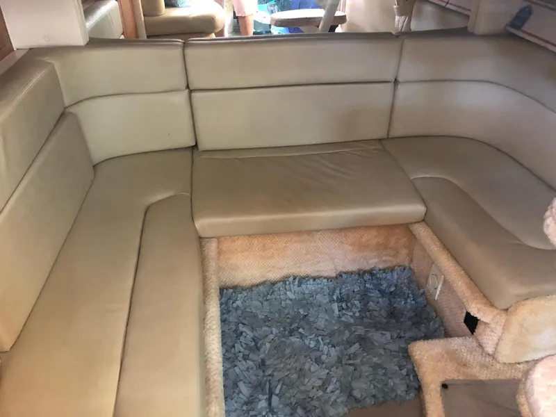 Slide: The Image of Interior of 2006 Sea Ray 320 Sundancer with beige leather seating and blue carpet. - 25