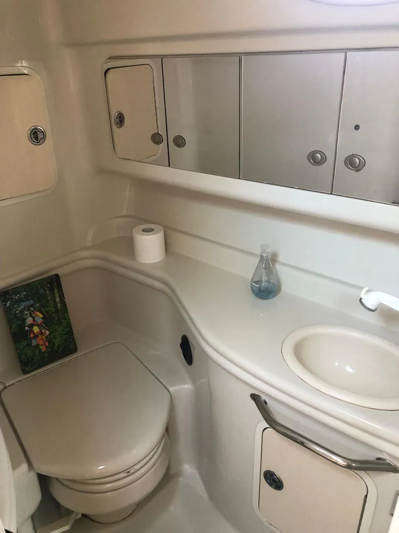 Slide: The Image of 2006 Sea Ray 320 Sundancer bathroom with sink, toilet, and storage cabinets. - 28