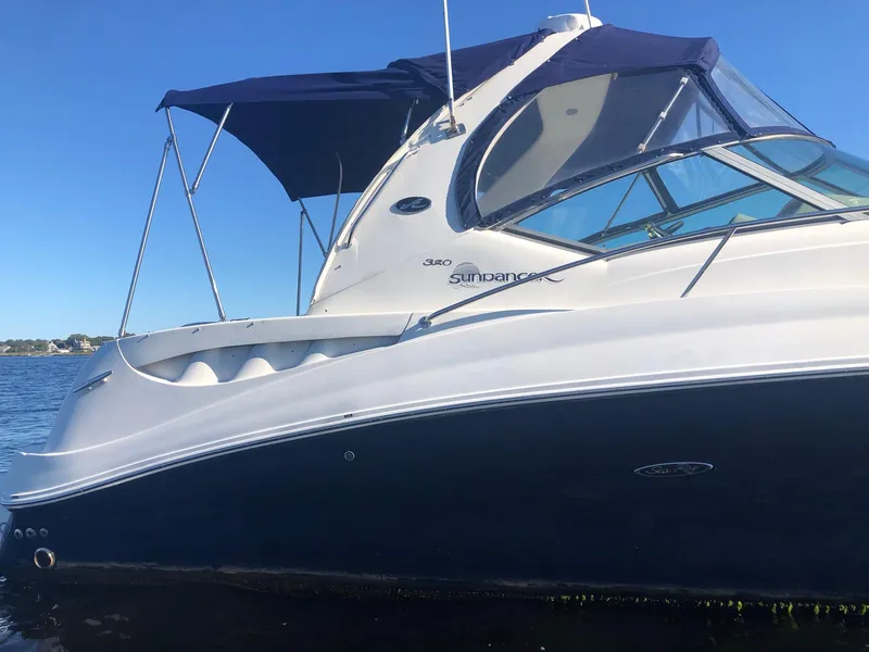 Slide: The Image of 2006 Sea Ray 320 Sundancer boat with blue canopy on calm water. - 3