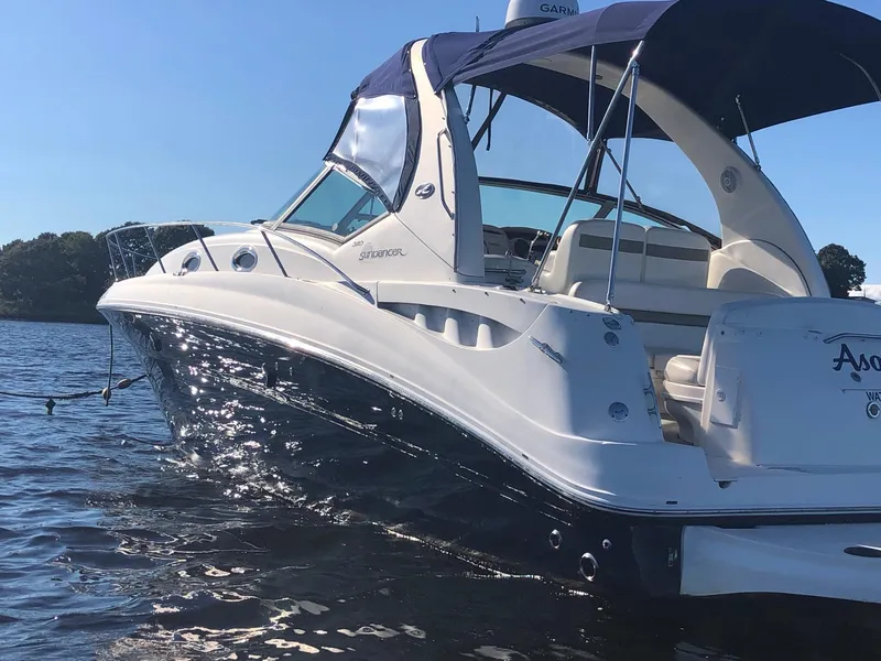 Slide: The Image of 2006 Sea Ray 320 Sundancer boat on water, featuring sleek design and blue canopy. - 5