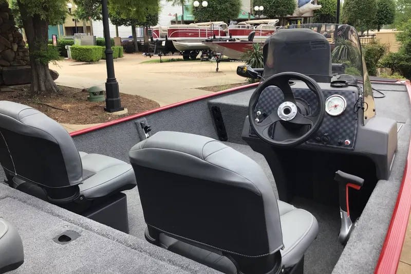 Slide: The Image of 2025 Tracker Bass Tracker Classic XL boat interior with steering wheel and seating. - 2