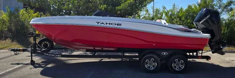 Slide: The Image of 2025 Tahoe T21 boat in red on a trailer, parked outdoors. - 0