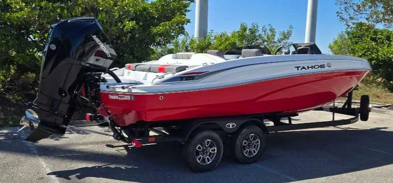 Slide: The Image of 2025 Tahoe T21 boat on trailer, red and white design, parked outdoors. - 10