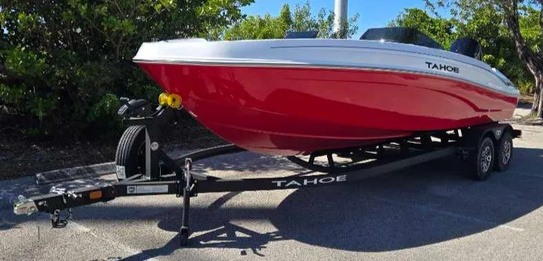 Slide: The Image of 2025 Tahoe T21 boat on trailer, red and white design, parked outdoors. - 2