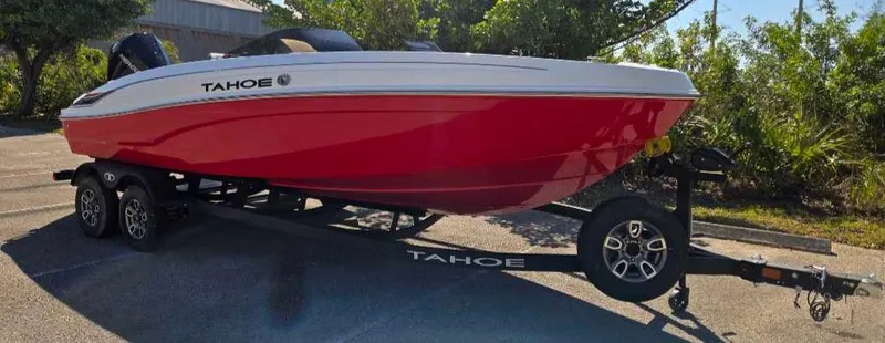 Slide: The Image of 2025 Tahoe T21 boat on trailer, red and white design, parked outdoors. - 3
