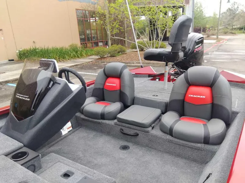 Slide: The Image of 2025 Tracker Pro Team 190 boat interior with gray and red seating, steering console, and motor. - 11