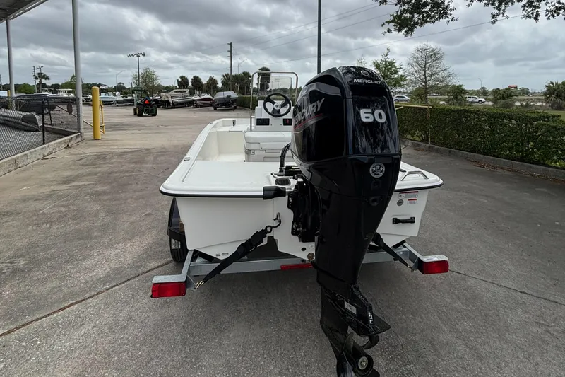 Slide: The Image of 2025 Mako Pro Skiff 15 CC with Mercury 60 outboard motor on trailer. - 2