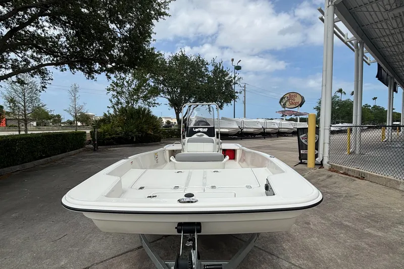 Slide: The Image of 2025 Mako Pro Skiff 15 CC boat on trailer, parked outdoors under cloudy sky. - 3