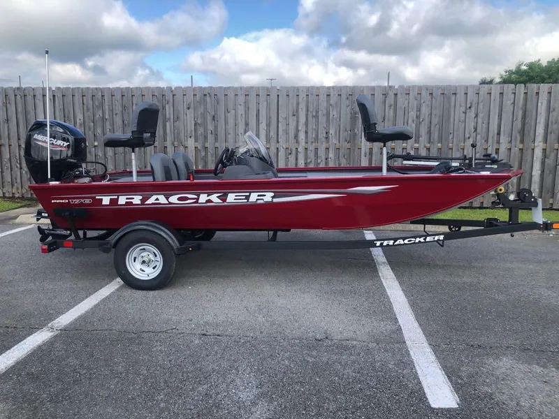 Slide: The Image of 2025 Tracker Pro 170 boat in red, parked on a trailer in a lot. - 12
