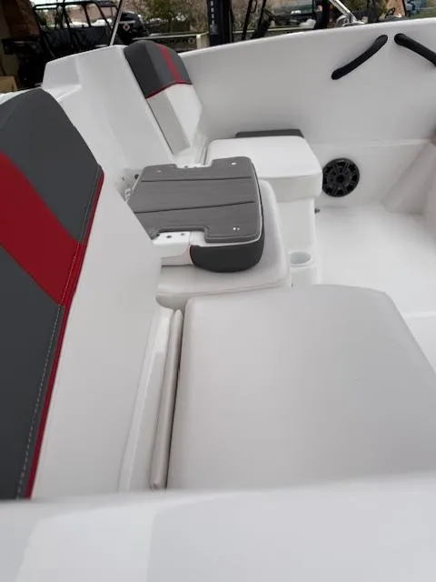 Slide: The Image of 2025 Tahoe T16 boat interior with gray and red seating, featuring a speaker and storage compartments. - 7