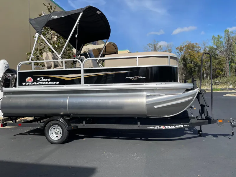 Slide: The Image of 2025 Sun Tracker Party Barge 16 DLX pontoon boat on trailer, outdoors. - 3