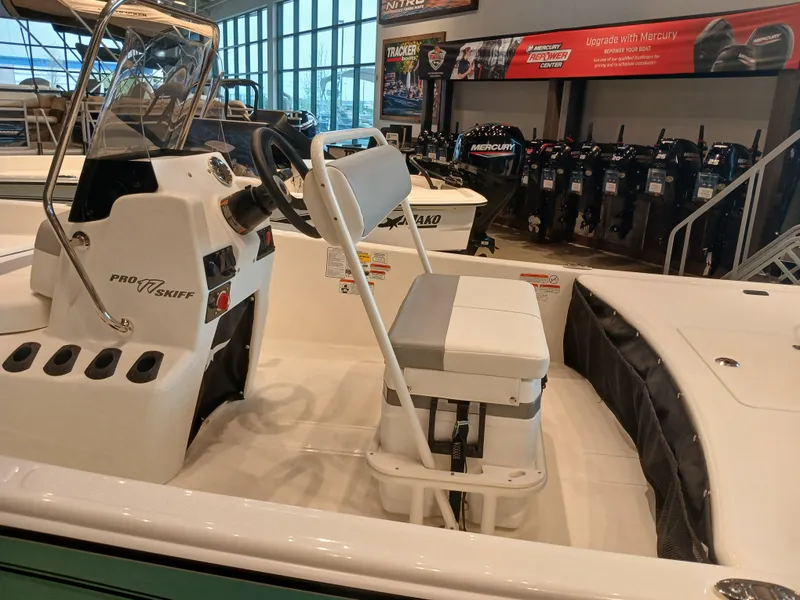 Slide: The Image of 2025 Mako Pro Skiff 17 CC boat interior with seating and console in showroom. - 5