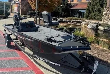 Slide: The Image of 2025 Tracker Pro 170 boat on display outdoors, featuring seating and fishing equipment. - 2