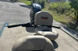 Slide: The Image of 2025 Tracker Bass Tracker Classic Limited boat with beige seating and motor in a parking area. - 7