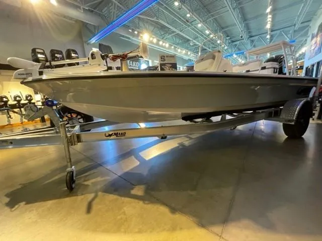 Slide: The Image of 2025 Mako 18 LTS boat displayed indoors on a trailer. - 1