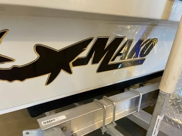 Slide: The Image of 2025 Mako 18 LTS boat logo on hull, displayed on a trailer. - 2