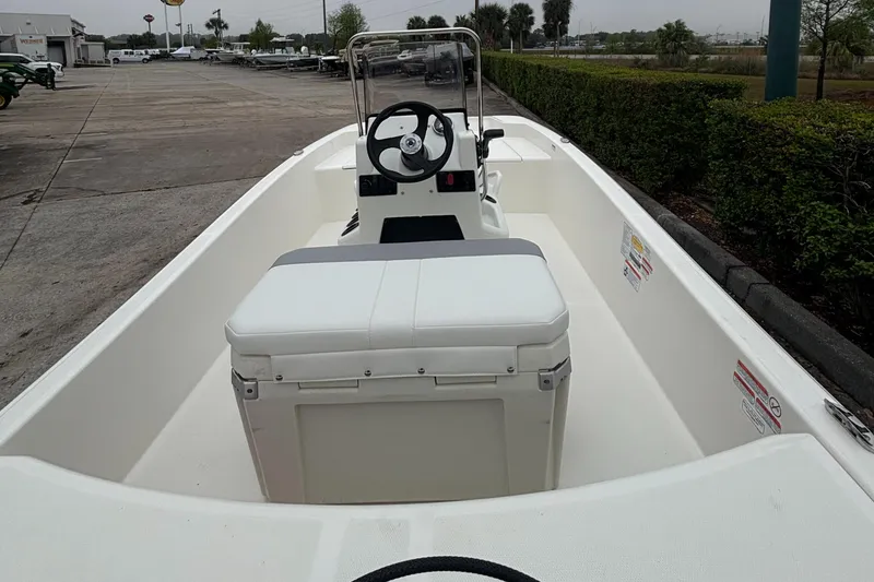 Slide: The Image of 2025 Mako Pro Skiff 15 CC boat interior with steering console and seating. - 2