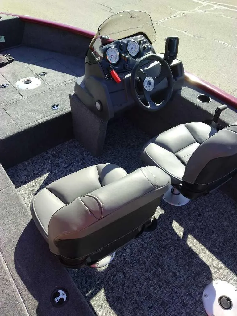 Slide: The Image of 2025 Tracker Super Guide V-16 SC boat interior with steering console and seating. - 2