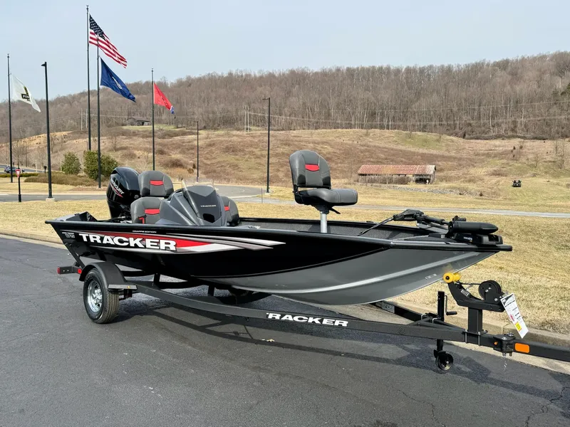 Slide: The Image of 2025 Tracker Pro Team 175 Crappie Edition boat on trailer, flags in background. - 3