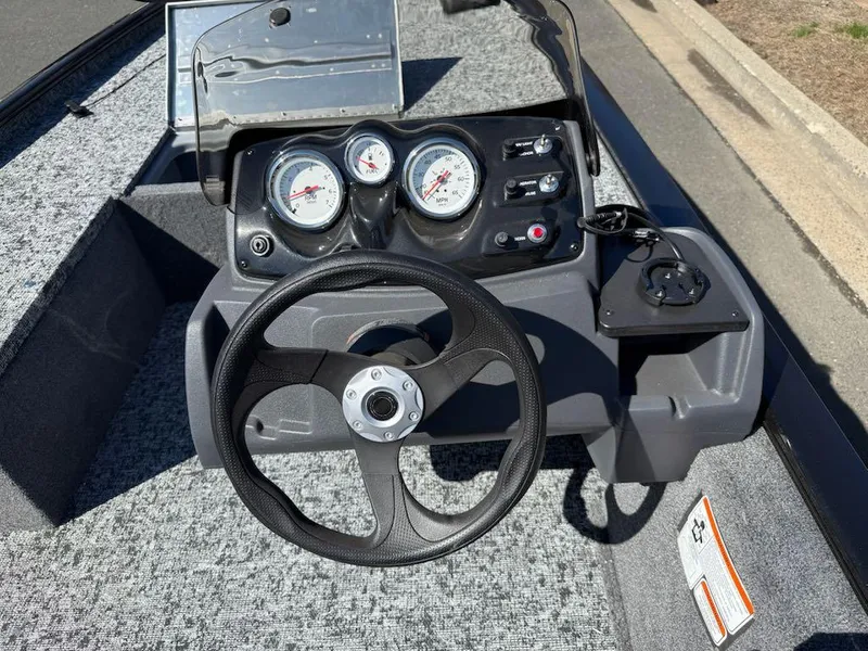 Slide: The Image of 2025 Tracker Pro 170 boat dashboard with steering wheel and gauges. - 2