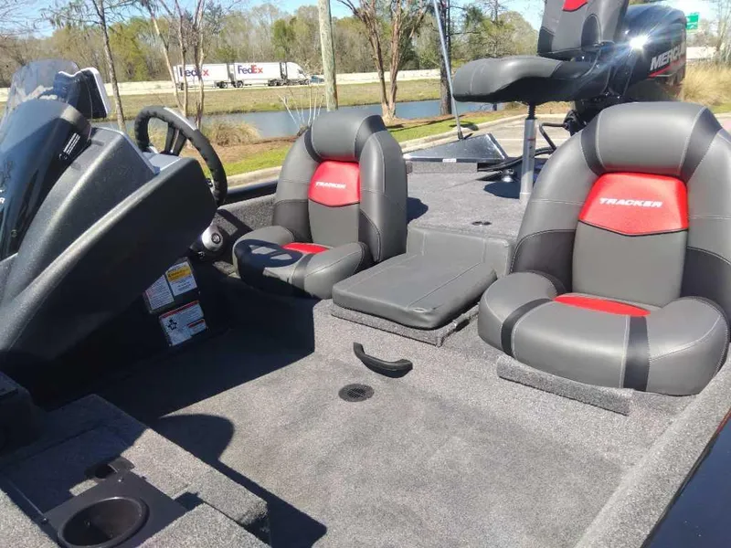 Slide: The Image of 2025 Tracker Pro Team 175 boat interior with gray and red seating, steering wheel, and console. - 10