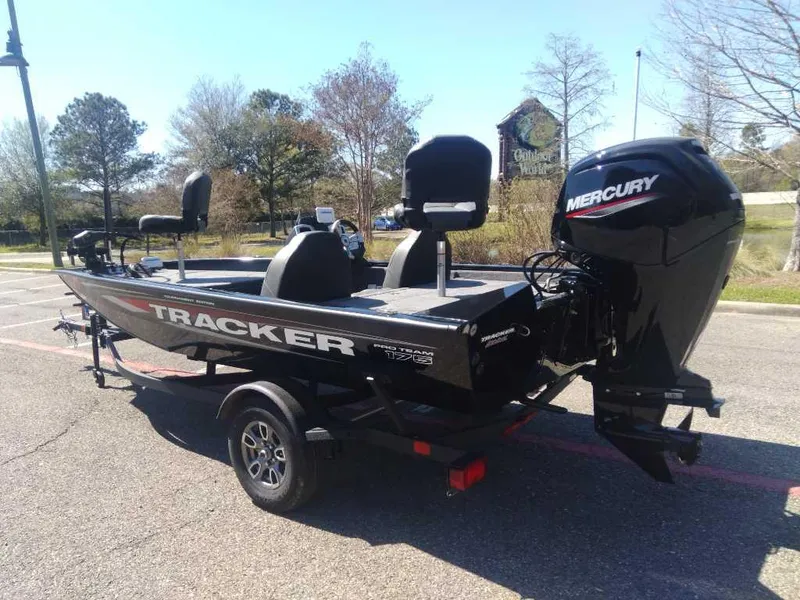 Slide: The Image of 2025 Tracker Pro Team 175 boat with Mercury engine in a parking lot. - 2