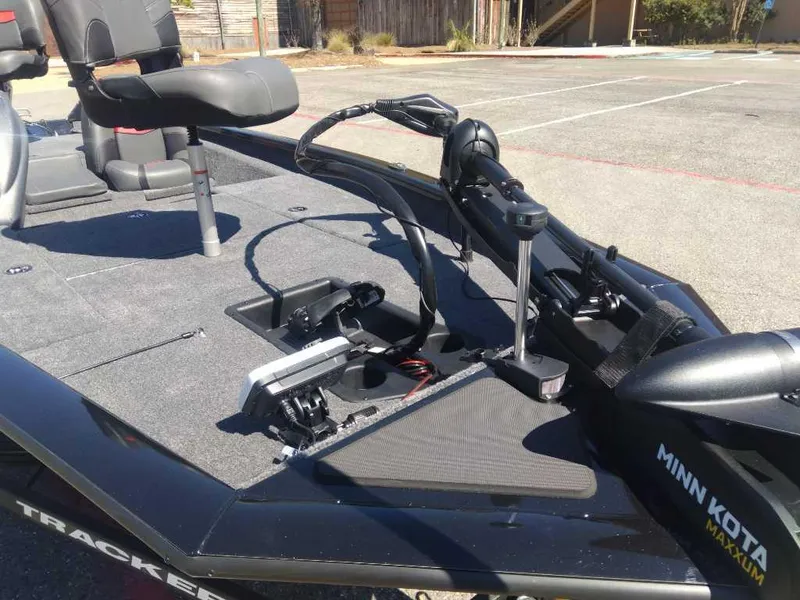 Slide: The Image of 2025 Tracker Pro Team 175 boat with Minn Kota trolling motor in a parking lot. - 8