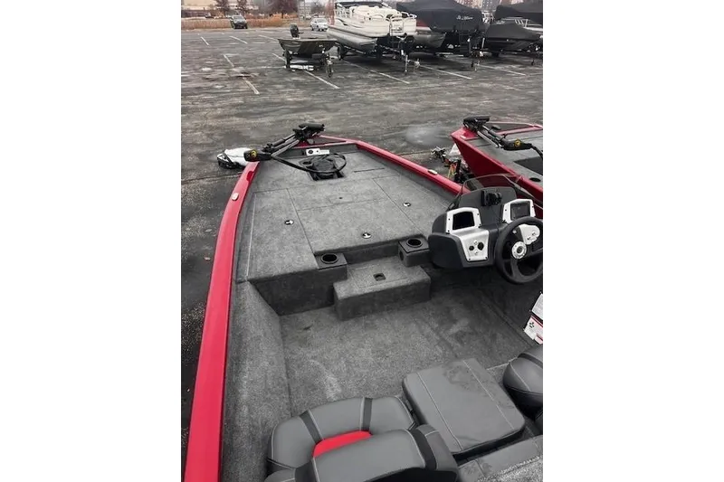 Slide: The Image of 2025 Tracker Pro Team 175 boat interior with steering console and seating, parked outdoors. - 61