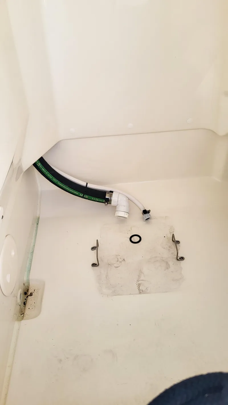 Slide: The Image of 2024 Boston Whaler 210 Montauk interior detail with visible plumbing components. - 19