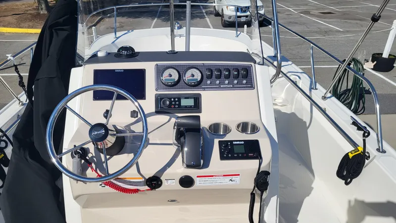 Slide: The Image of 2024 Boston Whaler 210 Montauk boat dashboard with steering wheel and controls. - 8